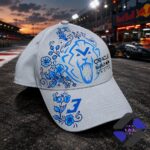 Red Bull Racing Cap with blue lion and floral design on race track